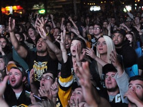 Pittsburgh Penguins fans, watching the game on a large screen in Market Square, react during the third period the team's 4-2 loss to the San Jose Sharks in Game 5 of the NHL hockey Stanley Cup finals, Thursday, June 9, 2016, in Pittsburgh.