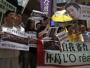 Protestors display placards with the picture of local singer Denise Ho outside a department store in Hong Kong's Times Square, Wednesday, June 8, 2016. French cosmetics company Lancome has sparked a backlash in Hong Kong after it canceled a promotional concert featuring a singer Ho known for her pro-democracy views, with many accusing it of caving to political pressure from Beijing. The banner reads "Boycott L'Oreal! No Self- censorship".