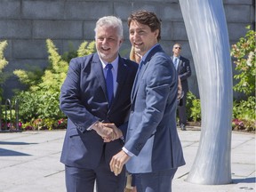 Quebec Premier Philippe Couillard shake hands with Canadian Prime Minister Justin Trudeau as he arrives at the Musee national des beaux-arts du Quebec to attend the official reception to mark la Fete nationale du Quebec in Quebec City on Friday June 24, 2016.