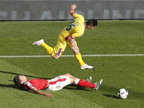 Romania's Steliano Filip, top, jumps on Switzerland's Fabian Schaer during the Euro 2016 Group A soccer match between Romania and Switzerland at the Parc des Princes stadium in Paris, France, Wednesday, June 15, 2016.