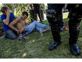 Sean Moore, 23, of Sacramento waits for medics with a friends after being stabbed by protesters at the State Capitol in Sacramento, Calif., on Sunday, June 26, 2016. Sacramento Fire Department spokesman Chris Harvey says a rally by KKK and other right-wing extremists groups turned violent Sunday when they were met by counterprotesters. (Renee C. Byer/The Sacramento Bee via AP)  MAGS OUT; LOCAL TELEVISION OUT (KCRA3, KXTV10, KOVR13, KUVS19, KMAZ31, KTXL40); MANDATORY CREDIT ORG XMIT: CASAB102