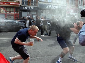 English fans flee after being pepper sprayed and tear gassed by French police  downtown Lille, Wednesday, June 15, 2016. (AP Photo/Michel Spingler)