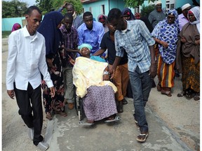Pepole help a wounded woman on June 26, 2016 the day after a terror attack on a hotel in the Somali capital Mogadishu that killed at least 11 people and was claimed by Al-Qaeda-affiliated al-Shabab militants. At least 11 people were killed on June 25, 2016 in an attack on a hotel in the Somali capital Mogadishu that was swiftly claimed by Al-Qaeda-affiliated Shabaab militants. The assault, the latest in a series by the Islamist group targeting hotels and restaurants, began when a suicide bomber detonated a car laden with explosives outside the building. /