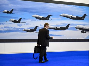 A visitor walks past the stand of Brazilian plane maker Embraer during the European Business Aviation Convention May 24, 2016 in Geneva.