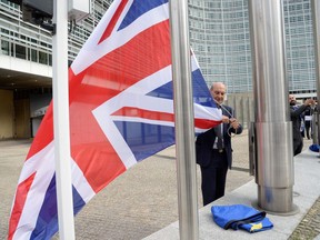 A member of the Commission removes a British flag during a European Summit at the EU headquarters in Brussels on Tuesday.