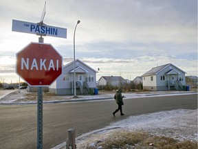 A woman walks past a stop sign, written in Innu, in Uashat, north-east of Montreal.