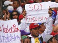 A man holds a sign reading "I am feminist" during a women rally with Venezuelan President Nicolas Maduro in Caracas on May 24, 2016.