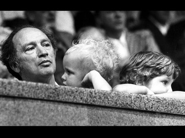 Prime Minister Pierre Trudeau watches Olympic Wrestling, while sons Alexandre (Sacha), age 2, centre, and Justin, age 4, seem content to watch the crowd. The Trudeaus visited the wrestling competition in Montreal July 24, 1976.
