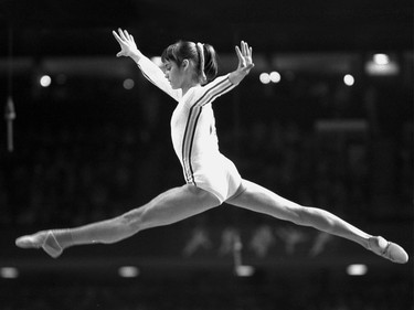 Nadia Comaneci, of Romania, performs a jump during compulsory events and optional exercises at the Montreal Summer Olympic Games on July 18,1976. All the world seemed to fall in love with the ponytailed 14-year-old who became the first gymnast to earn a perfect 10 score.