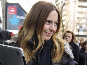 MONTREAL, QUE.: November 27, 2014 -- Pierre Karl Peladeau's partner Julie Snyder waves to cameramen and reporters gathered outside Parti Quebecois headquarters in Montreal Thursday November 27, 2014. Peladeau was going to the PQ office to sign papers after announcing his intention to run for the leadership of the party.  Snyder's production company has offices in the same building.  (John Mahoney / MONTREAL GAZETTE)