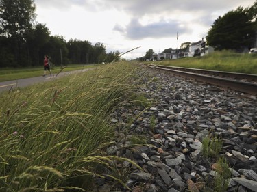 LAC MEGANTIC, QUE.: JUNE 27, 2016 -- A woman walks on a trail beside the train line in Lac Mégantic, Qc. about 250 kms from Montreal Monday, June 27, 2016 that a train carrying cars with crude oil derailed from July 6, 2013. The resulting accident/fire killed 47 people, destroyed much of downtown and polluted the environment. (John Kenney / MONTREAL GAZETTE)