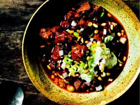 A western chili made with cubes of lamb is topped with onions and sour cream.