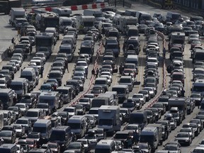A tailback, in British English, refers to a long line of stationary or barely moving vehicles: Lines of traffic queue to enter the port of Dover on the south coast of England on July 24, 2016. British officials were drafted in to help French border police on Sunday after 15-hour queues built up at the port of Dover due to heightened entry checks. The local Kent Police force said there was a 12-mile tailback.