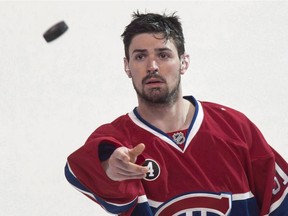 Montreal Canadiens' goalie Carey Price tosses a puck to the crowd following a victory while visiting the Detroit Red Wings during overtime in NHL hockey action on April 9, 2015 in Montreal.