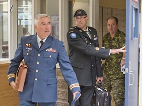 Warrant officer Andre Gagnon, centre, walks to testify at his court martial at the St-Malo Armoury Tuesday, August 12, 2014 in Quebec City with his defence counsel Major Philippe-Luc Boutin, left.