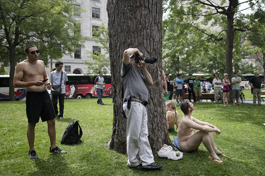 A man takes photos as people gather to take part in the World Naked Bike Ride at Dorchester Square in Montreal on Saturday, July 16, 2016. The World Naked Bike Ride event aims to encourage cycling, promote environmentalism, and address body image issues.