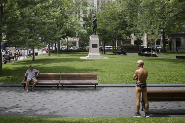 A naked man waits to take part in the World Naked Bike Ride at Dorchester Square in Montreal on Saturday, July 16, 2016. The World Naked Bike Ride event aims to encourage cycling, promote environmentalism, and address body image issues.