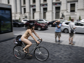 A woman takes part in the World Naked Bike Ride at Dorchester Square in Montreal on Saturday, July 16, 2016. The World Naked Bike Ride event aims to encourage cycling, promote environmentalism, and address body image issues.