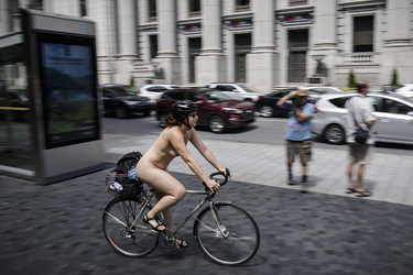A woman takes part in the World Naked Bike Ride at Dorchester Square in Montreal on Saturday, July 16, 2016. The World Naked Bike Ride event aims to encourage cycling, promote environmentalism, and address body image issues.
