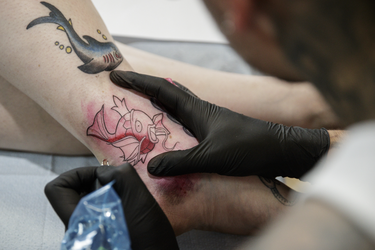 Pokemon fan Sandrine gets a tattoo of the character Magikarp from tattoo artist Cory Crosbie as part of a Pokemon Go promotion day at DFA Tattoos in Montreal on Sunday, July 24, 2016.