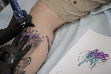 Pokemon fan Megan Muir gets a tattoo of the character Suicune from tattoo artist Melissa Valiquette as part of a Pokemon Go promotion day at DFA Tattoos in Montreal on Sunday, July 24, 2016.