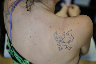 Pokemon fan Billie Prudence gets ready for a tattoo of the character Leafeon from tattoo artist Yannis Panos as part of a PokemonGo promotion day at DFA Tattoos in Montreal on Sunday, July 24, 2016.