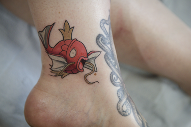 Pokemon fan Sandrine shows a tattoo of the character Magikarp from tattoo artist Cory Crosbie as part of a Pokemon Go promotion day at DFA Tattoos in Montreal on Sunday, July 24, 2016.