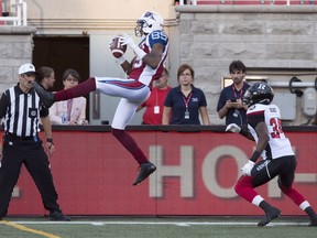 Montreal Alouettes wide receiver Duron Carter, left, catches a pass ahead of Ottawa Redblacks defensive back Jonathan Rose during first quarter CFL football action, in Montreal on Thursday, June 30, 2016.