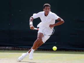 Felix Auger-Aliassime of Canada returns to Alex De Minaur of Australia during their boy's singles match on day 11 of the Wimbledon Tennis Championships July 7, 2016.