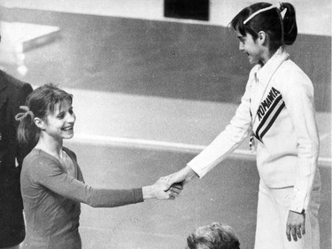 Soviet Gymnast Olga Korbut congratulates Romanian counterpart Nadia Comaneci on the podium at the 1976 Montreal Games. Comaneci had just won the gold medal in the balance beam competition where she received a perfect 10 from the judges. Korbut scored 9.9 to the silver medal.