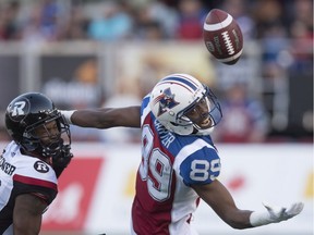 The ball drops out of reach of Montreal Alouettes wide receiver Duron Carter, right, as Ottawa Redblacks defensive back Forrest Hightower covers during second quarter CFL football action in Montreal on Thursday, June 30, 2016.