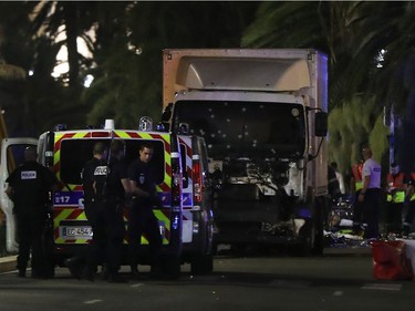 Police officers and rescued workers stand near a van that ploughed into a crowd leaving a fireworks display in the French Riviera town of Nice on July 14, 2016. The mayor of the French city of Nice said dozens of people were likely killed after a van rammed into a crowd marking Bastille Day in the French Riviera resort today and urged residents to stay indoors.