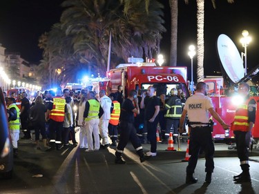 EDITORS NOTE: Graphic content / Police officers, firefighters and rescue workers are seen at the site of an attack on July 15, 2016, after a truck drove into a crowd watching a fireworks display in the French Riviera town of Nice. A truck ploughed into a crowd in the French resort of Nice on July 14, leaving at least 60 dead and scores injured in an "attack" after a Bastille Day fireworks display, prosecutors said on July 15.