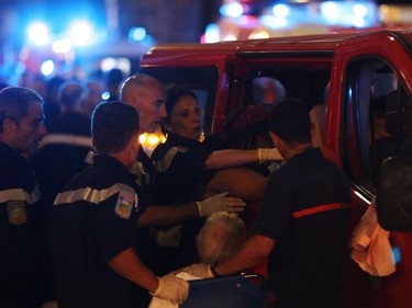 EDITORS NOTE: Graphic content / Rescue workers help injured people to get in a ambulance on July 15, 2016, after a truck drove into a crowd watching a fireworks display in the French Riviera town of Nice. A truck ploughed into a crowd in the French resort of Nice on July 14, leaving at least 60 dead and scores injured in an "attack" after a Bastille Day fireworks display, prosecutors said on July 15.