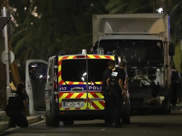 Police officers stand near a van that ploughed into a crowd leaving a fireworks display in the French Riviera town of Nice on July 14, 2016. Up to 30 people are feared dead and over 100 others were injured after a van drove into a crowd watching Bastille Day fireworks in the French resort of Nice on July 14, a local official told French television, describing it as a "major criminal attack".