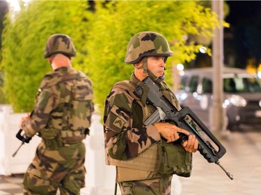 French soldiers stand guard by the sealed off area of an attack after a truck drove on to the sidewalk and plowed through a crowd of revelers who'd gathered to watch the fireworks in the French resort city of Nice, southern France, Friday, July 15, 2016. A spokesman for France's Interior Ministry says there are likely to be "several dozen dead" after a truck drove into a crowd of revelers celebrating Bastille Day in the French city of Nice.