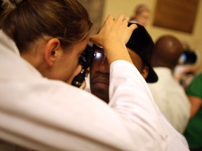 A doctor checks a patient's eyes.