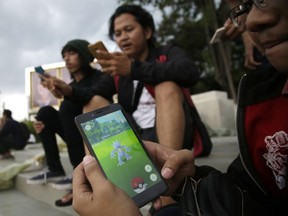 In this Monday, July 18, 2016 photo, an Indonesian man shows his smartphone as he plays "Pokemon Go" in Jakarta, Indonesia. The hugely popular game has sparked a frenzy among Indonesian players despite the application not officially available in the country.