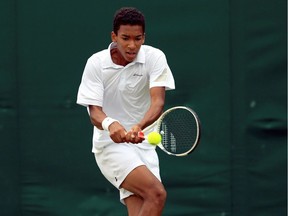 In this Sunday, July 3, 2016  photo, Canadian Félix Auger Aliassime returns a shot to Britain's Alastair Gray on day seven of the Wimbledon Tennis Championships in London.