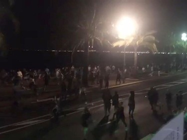 In this UGC video grab provided by Harp Detective on Thursday July 14, 2016, people run out from the scene after a truck drove on to the sidewalk and plowed through a crowd of revelers who'd gathered to watch the fireworks in the French resort city of Nice. Officials and eyewitnesses described as a deliberate attack. There appeared to be many casualties.