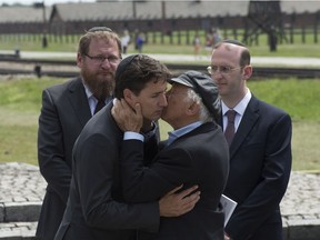 Auschwitz survivor Nate Leipciger embraces Canadian Prime Minister Justin Trudeau after presenting him with a book as Director of the Auschwitz-Birkenau State Museum Dr. Piotr Cywinski (back left) and Rabbi Adam Scheier (right) look on following a tour of the Auschwitz-Birkenau State Museum in Auschwitz, Poland Sunday July 10, 2016.