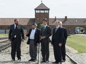 Canadian Prime Minister Justin Trudeau listens to  Auschwitz survivor Nate Leipciger (second from left) as he tours the Auschwitz-Birkenau State Museum with Dr. Piotr Cywinski(left) and Rabbi Adam Scheier and Foreign Affairs Minister Stephane Dion (right) in Auschwitz, Poland Sunday July 10, 2016.