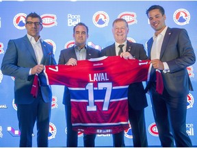 Montreal Canadiens general manager Marc Bergevin, left to right, team owner Geoff Molson, Laval Mayor Marc Demers and Place Bell manager Vincent Lucier pose for photos at a news conference Monday, July 11, 2016 in Laval, Quebec. The team announced they will move their American Hockey League affiliate, the St. John's IceCaps, to Laval for the start of the 2017 season.