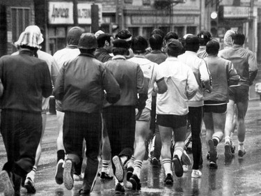 April 1976: Men jogging in the rain on a Montreal street.