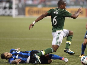 Montreal Impact's Lucas Ontivero tackles Portland Timbers' Darlington Nagbe as the Portland Timbers and Montreal Impact finished in a 1-1 tie in an MLS soccer match at Providence Park Wednesday, July 13, 2016, in Portland, Ore. (Pete Christopher/The Oregonian via AP)