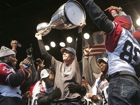 Alouettes head coach Marc Trestman holding the Grey Cup and  celebrating with players after a parade on Dec. 1, 2010.