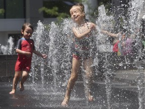 Heloise Charette, 4, runs through the fountain with brother Alexandre,  during lunch hour spent with mom and dad at Victoria Square on Tuesday July 12, 2016.