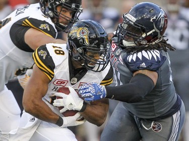 Alouettes' Alan-Michael Cash, right, tackles Hamilton Tiger-Cats Anthony Woodson during Canadian Football League game in Montreal. Friday. July 15, 2016.