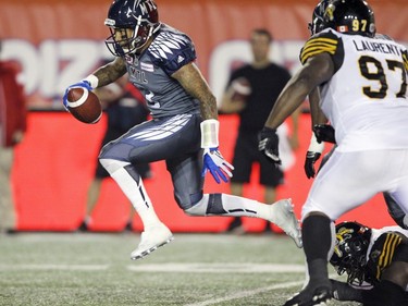 Alouettes quarterback Vernon Adams Jr. hops over a tackle attempt by a Hamilton Tiger-Cats defender during Canadian Football League game in Montreal, Friday, July 15, 2016.