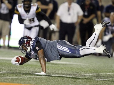 Alouettes receiver Nik Lewis dives for extra yards after making a catch against the Hamilton Tiger-Cats during Canadian Football League game in Montreal, Friday, July 15, 2016.